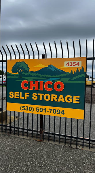 A custom business sign is mounted on the enter gate for Chico Self Storage. The sign is brightly colored and features their business name.