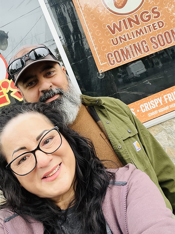Owners Jessica and Jesse stand in front of external signs for a new restaurant in Butte County.